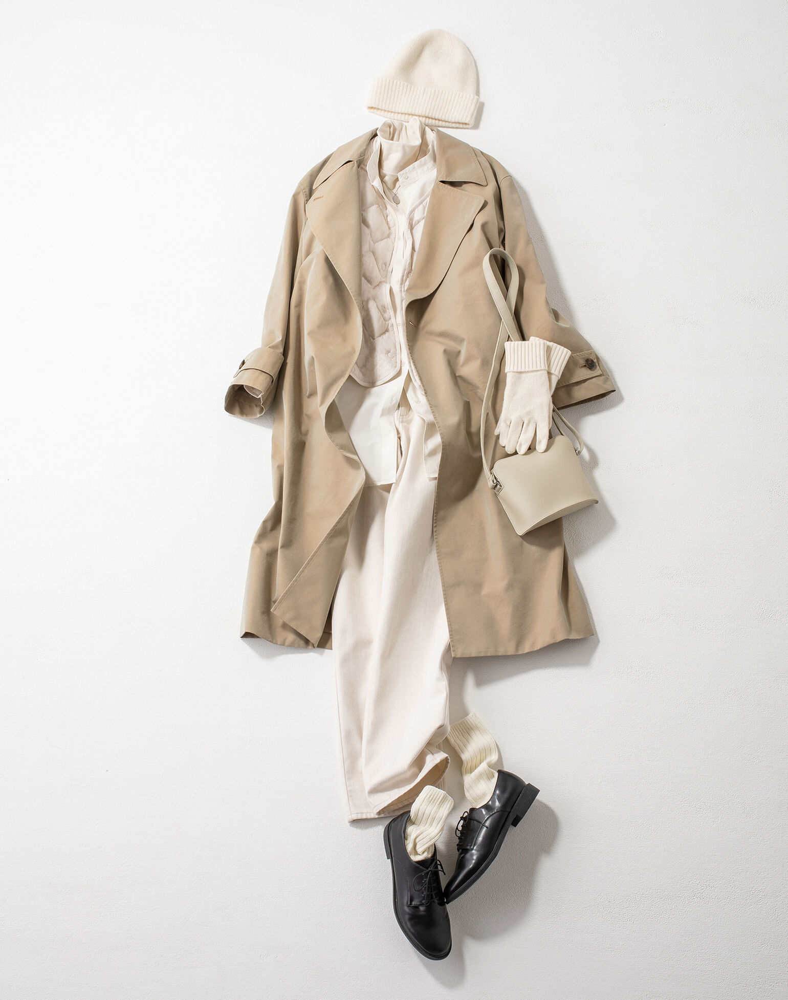 ベージュのトレンチコートに白のウルトラライトダウンリラックスジャケットを合わせたコーデ