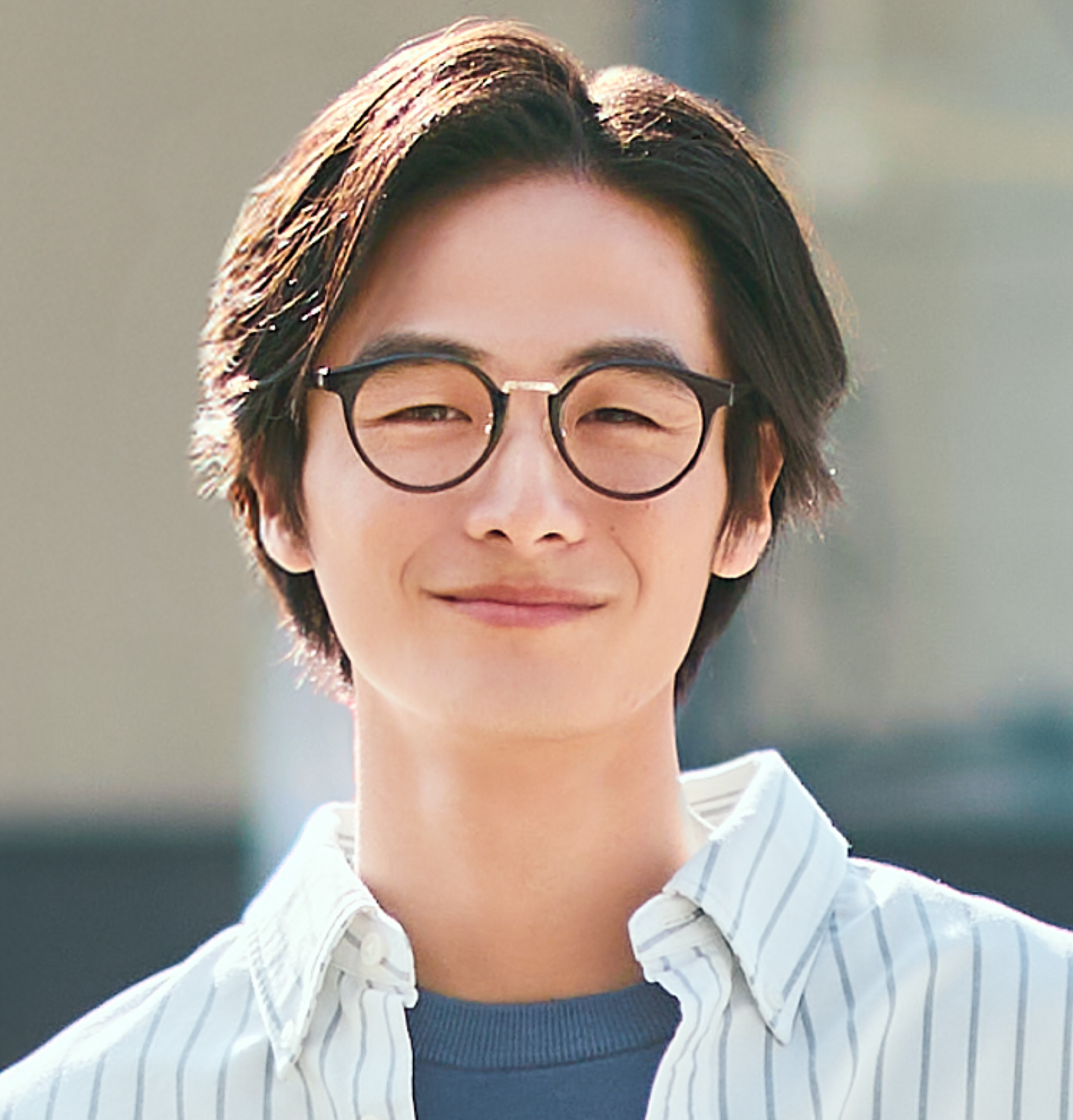 ボストンコンビタイプのサングラスを着用した男性が、柔らかな光の中でカメラに向かって爽やかに微笑んでいるポートレート画像。